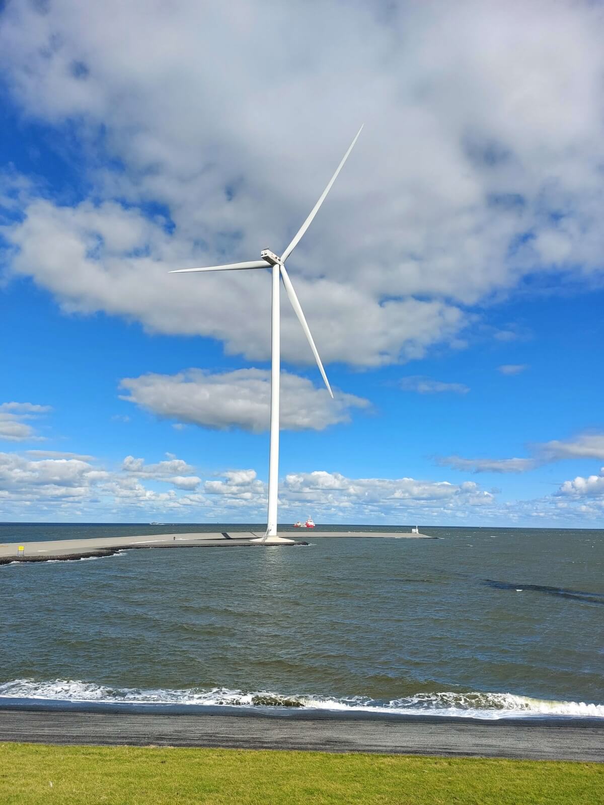 Een windmolen op een zonnige dag bij de Eemshaven